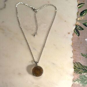 Silver Necklace with polished Pendant encircled by crystals.